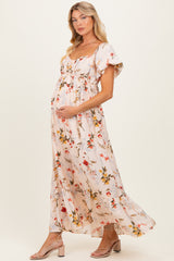 woman wearing a floral maternity maxi dress with short flutter sleeves and a visible baby bump