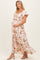 woman wearing a floral maternity maxi dress with short flutter sleeves and a visible baby bump