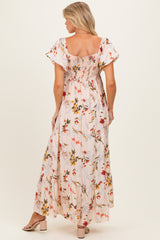woman wearing a floral maternity maxi dress with puff sleeves and a smocked back, showcasing a baby bump