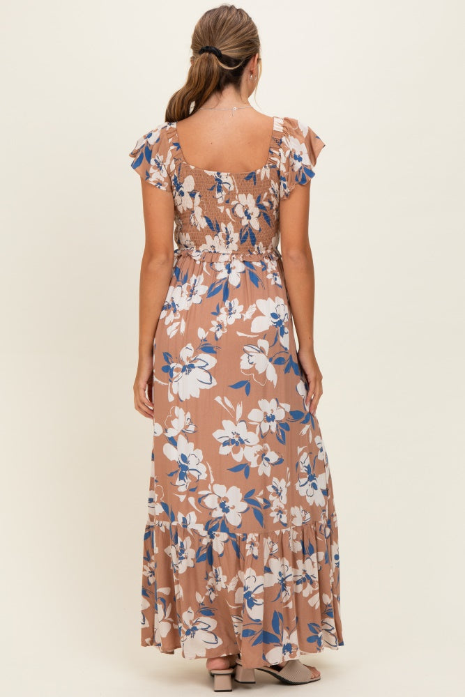 woman wearing a floral print brown maxi dress with a smocked bodice and ruffle sleeves, seen from the back