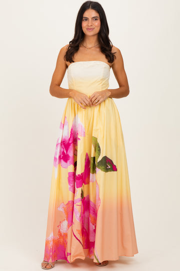 woman wearing a strapless yellow maxi dress with large pink floral print