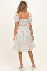 woman wearing a floral print maternity dress with puff sleeves and a square neckline, shown from the back