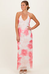 woman wearing a floral maxi dress with pink flowers and a deep v-neckline, styled with heels and jewelry