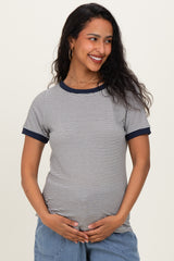 woman wearing a navy and white striped maternity top and holding her baby bump