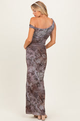woman wearing a floral off-the-shoulder maternity gown with a fitted silhouette and flowing skirt, showing her back