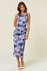 woman wearing a sleeveless purple and blue tie-dye midi dress with a form-fitting silhouette and side ruching