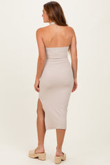 woman wearing a beige strapless midi dress with a side slit and minimal back detail