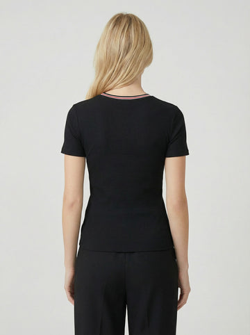 woman wearing a black ribbed short sleeve top, shown from the back, paired with black pants