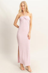 woman wearing a pink and white striped halter neck maxi dress with side slits