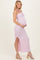 woman wearing a pink and white striped maternity maxi dress with a halter neck and side slit, showing her baby bump