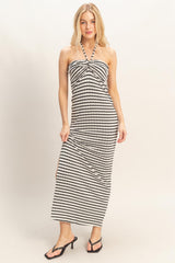 woman wearing a black and white striped halter maxi dress with a front twist detail and side slits