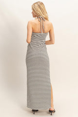 woman wearing a black and white striped maxi dress with a halter neck and back tie detail