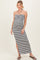 woman wearing a black and white striped maternity maxi dress with a halter neck and a side slit, showcasing her baby bump