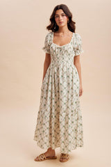 woman wearing a cream floral maxi dress with puff sleeves and ruffle hem, standing on a neutral background