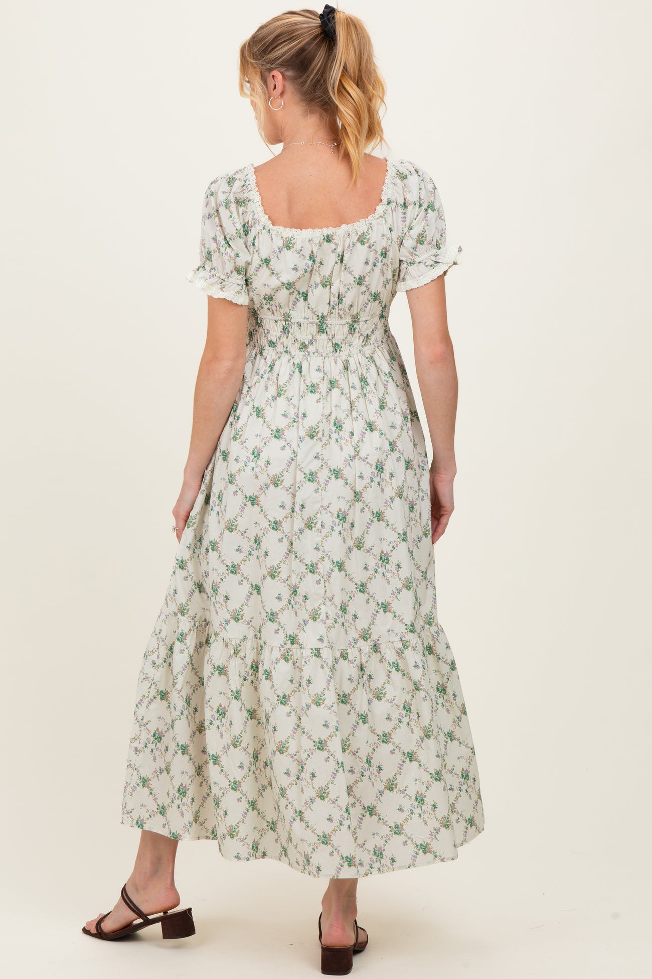 woman wearing a floral print maternity maxi dress with puff sleeves and a smocked back, showing her baby bump