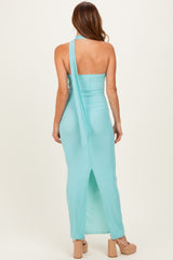 woman wearing a backless light blue maxi dress with a high slit and a tied halter neck detail