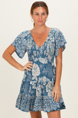 woman wearing a blue floral print dress with a v-neckline and flutter sleeves