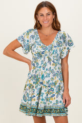 woman wearing a short white floral print dress with puffed sleeves and a gathered waist