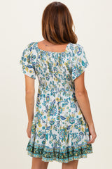 woman wearing a white floral print smocked mini dress with short sleeves and a ruffled hem