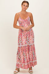 woman wearing a pink floral maxi dress with spaghetti straps and tiered skirt