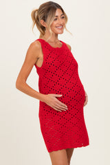 woman wearing a red crochet maternity dress and holding her baby bump