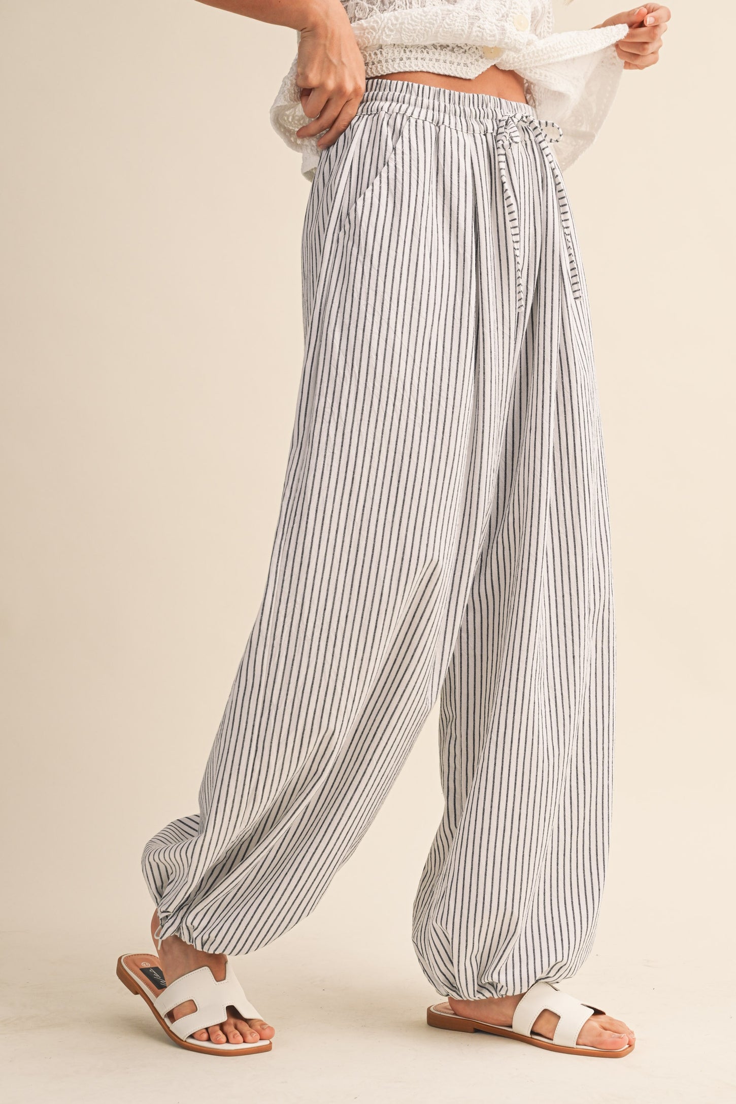 woman wearing white and gray striped wide-leg pants with an elastic waistband and a relaxed fit