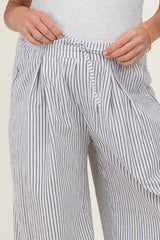 woman wearing striped maternity pants with a drawstring waist, hands holding the waistband