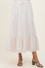 woman wearing a light pink maternity skirt with floral print and ruffle hem