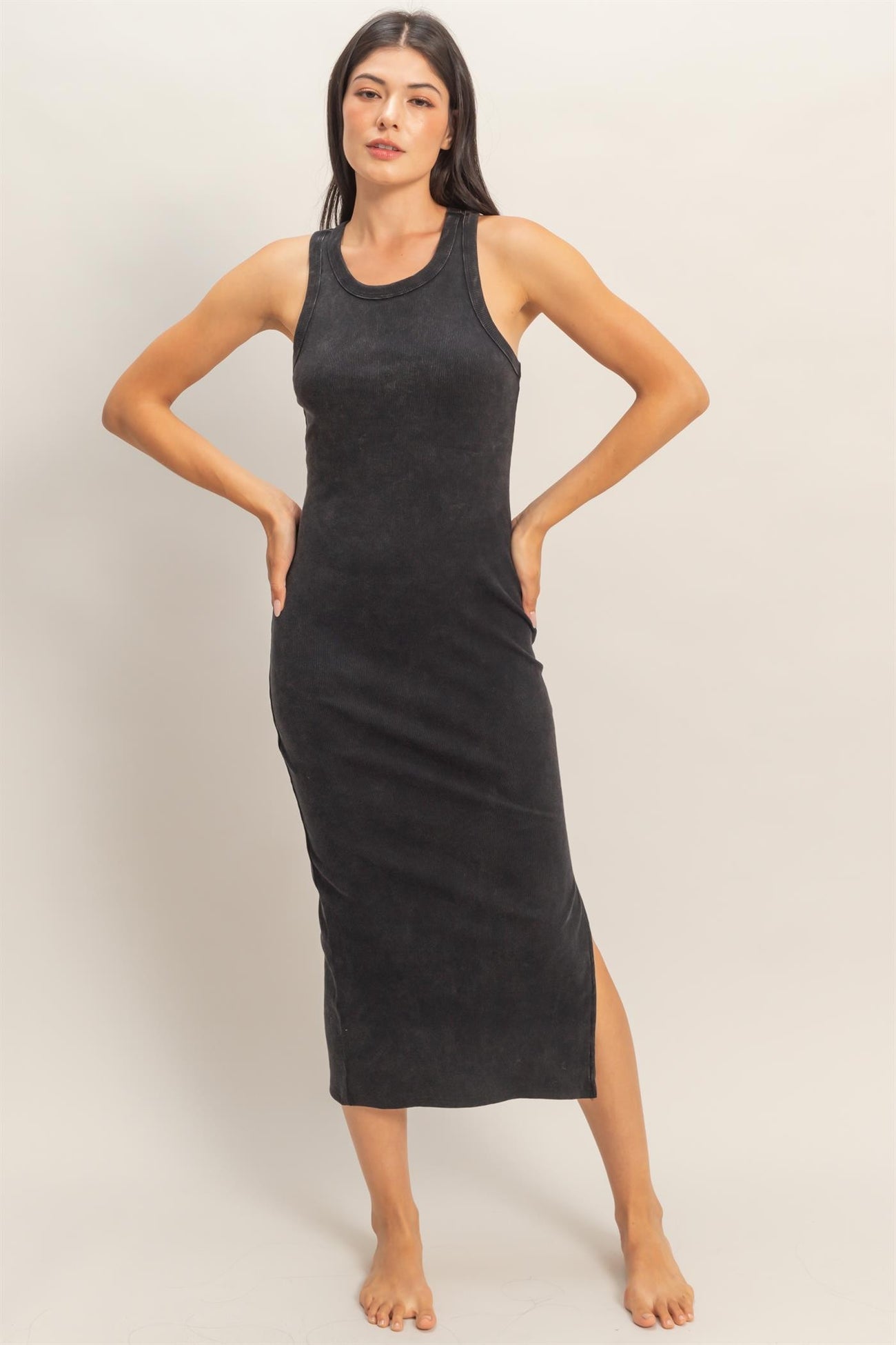 woman wearing a black sleeveless midi dress with a side slit