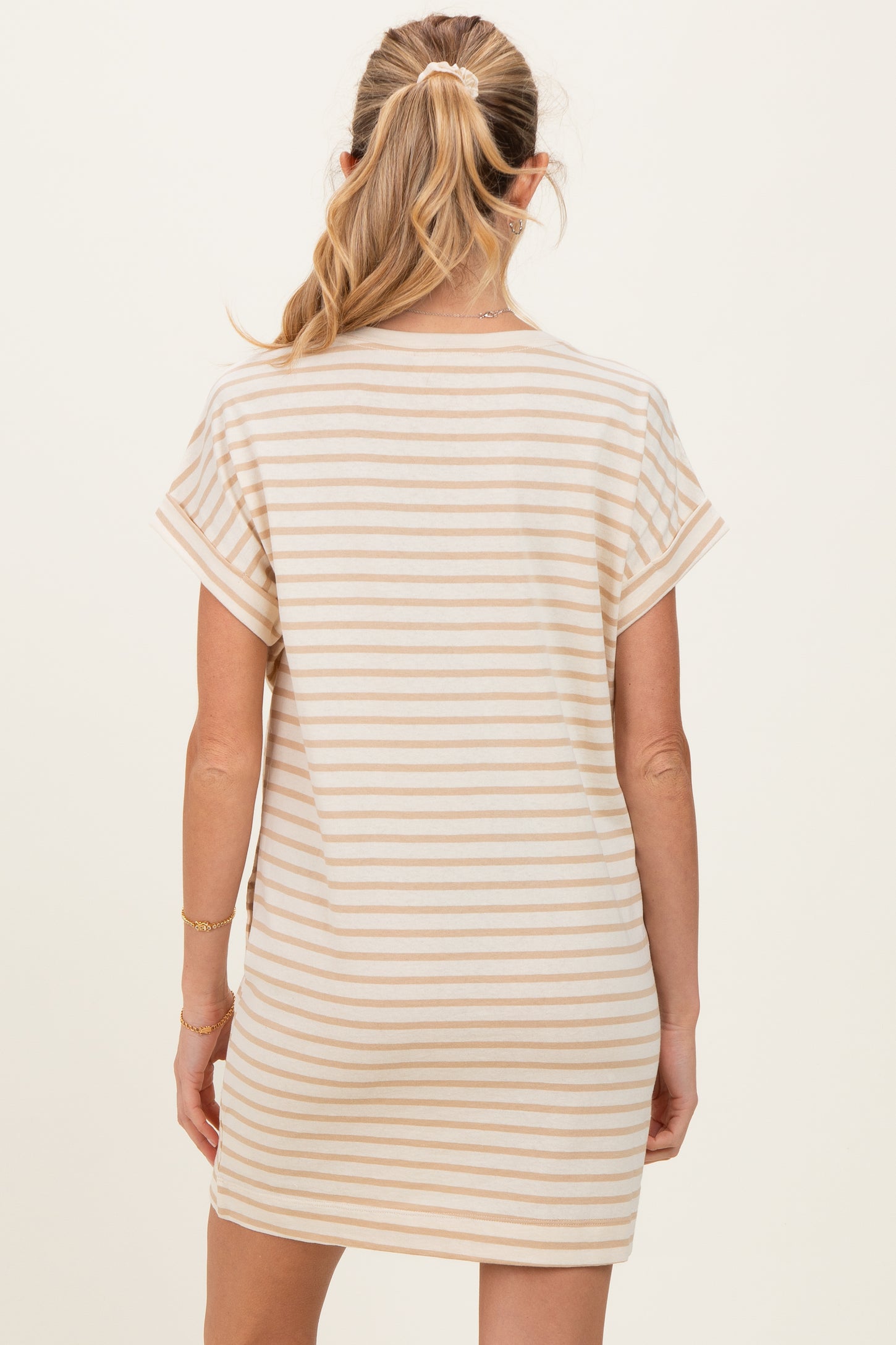 woman wearing a striped maternity dress with short sleeves, showing the back view