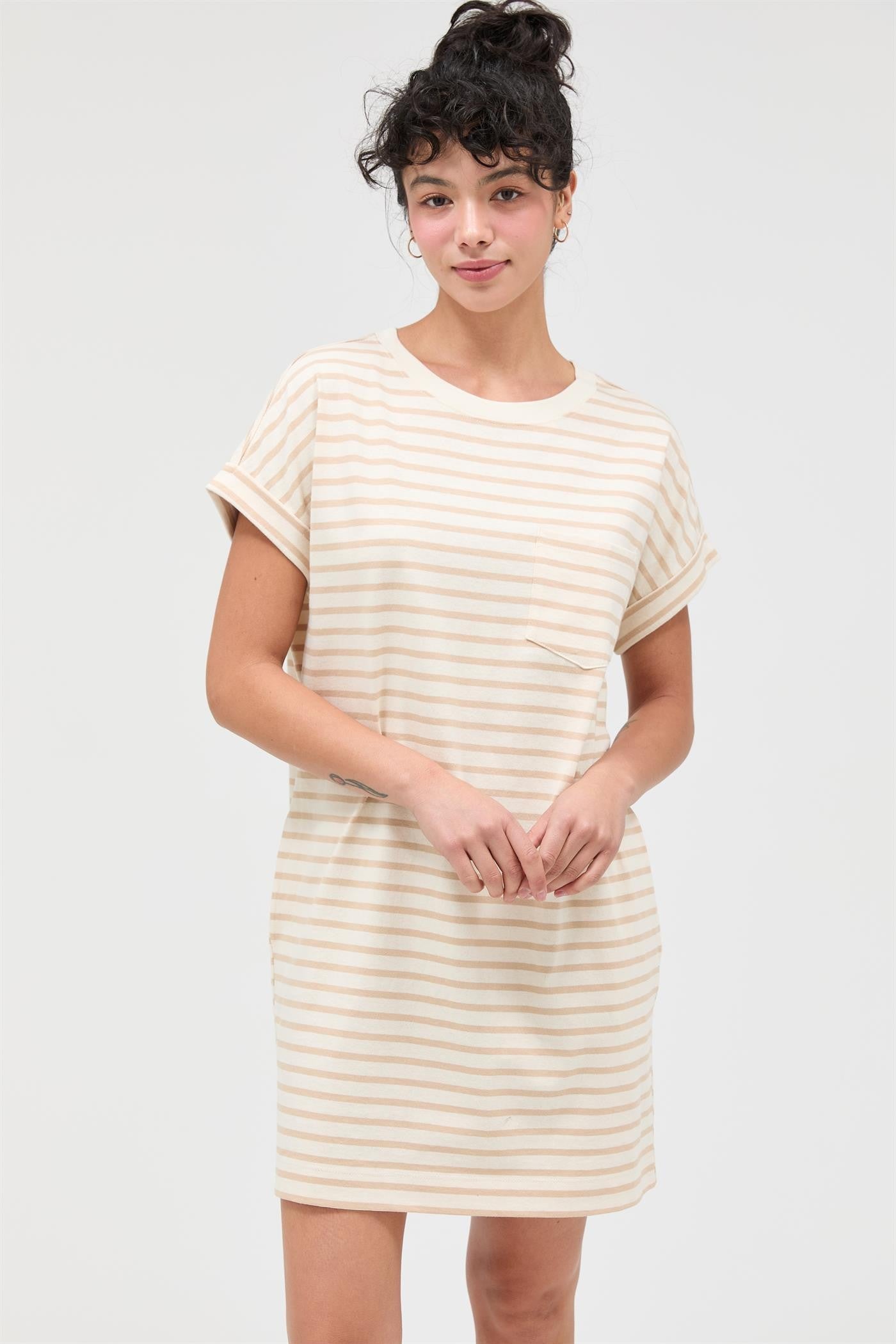 woman wearing a cream striped short sleeve dress with a chest pocket and rolled sleeves