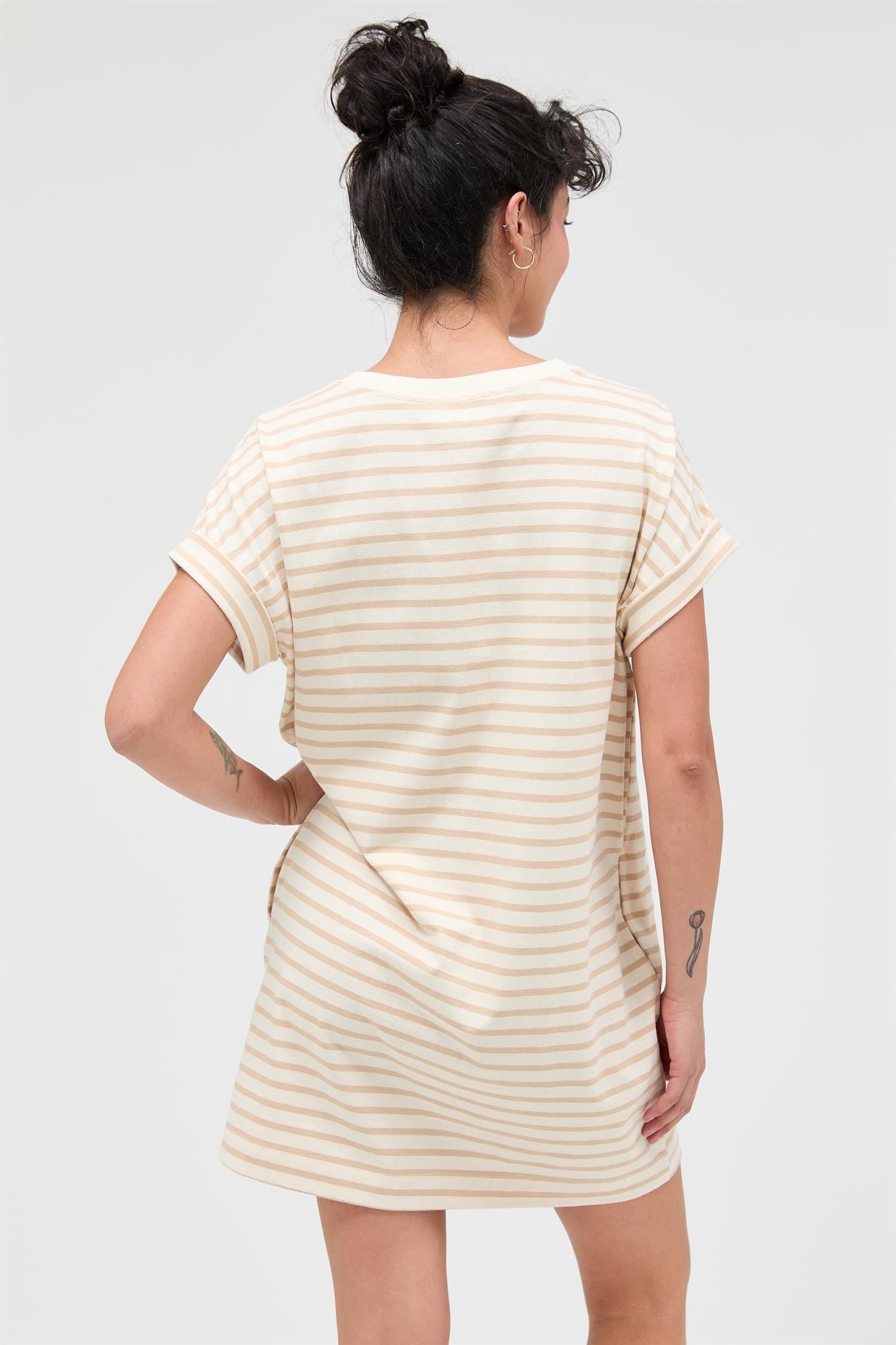 woman wearing a striped short sleeve shift dress with rolled cuffs, shown from the back