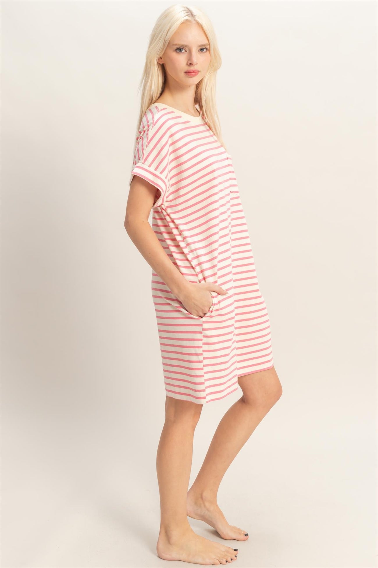 woman wearing a pink and white striped short sleeve dress with pockets
