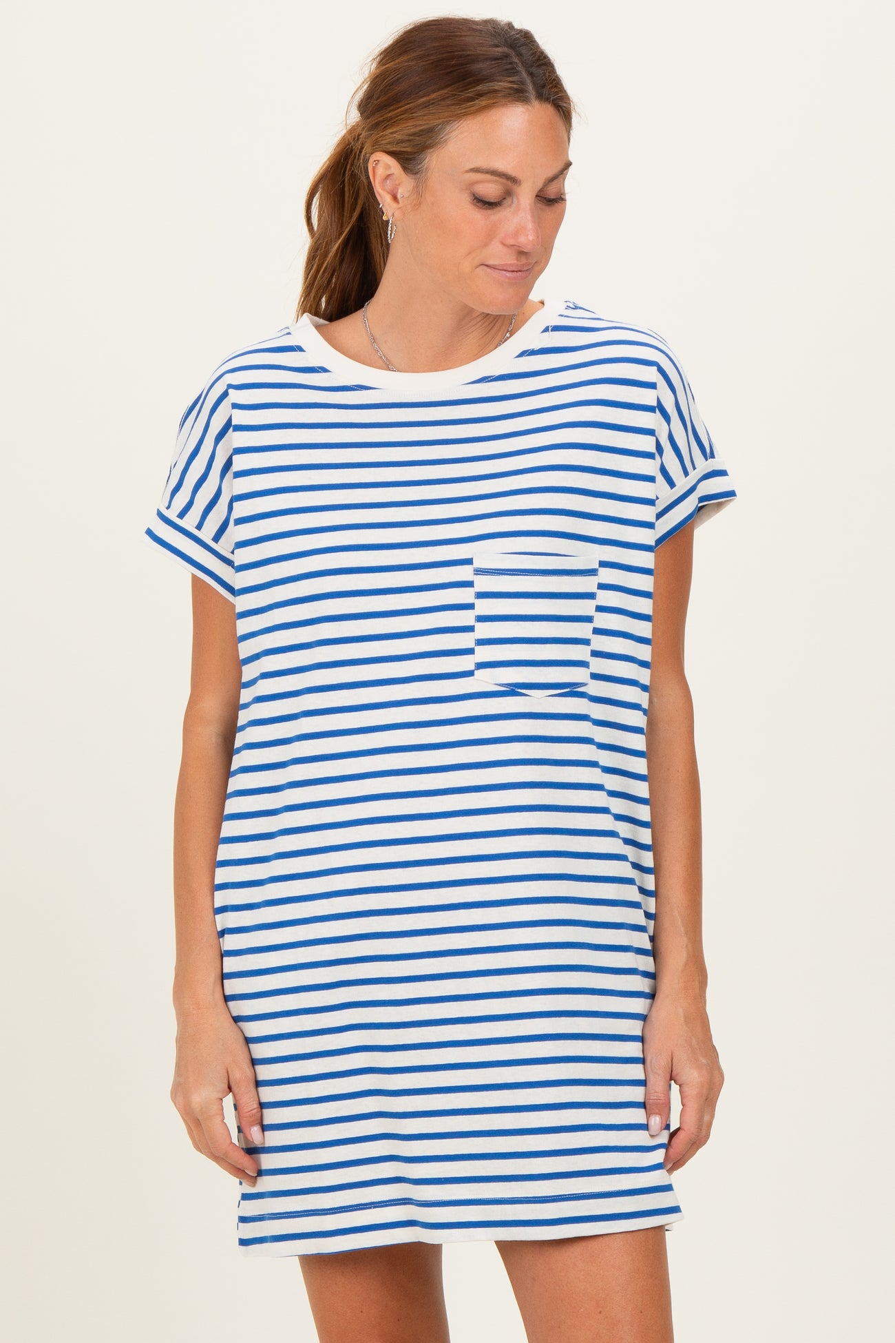 woman wearing a white and blue striped t-shirt dress with a pocket on the chest