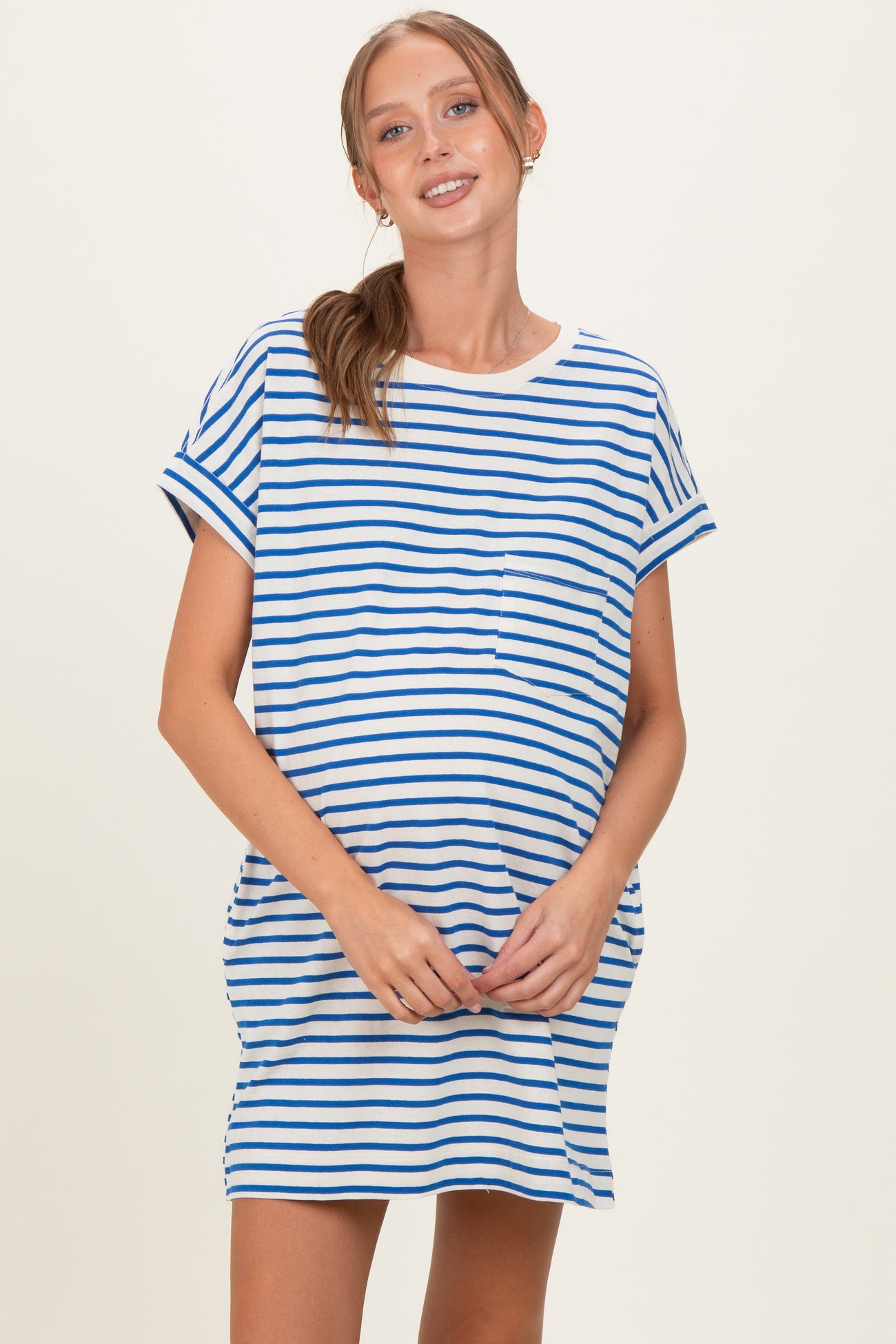 woman wearing a blue and white striped maternity t-shirt dress with a relaxed fit and short sleeves, holding her baby bump