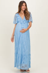 woman wearing a light blue lace maternity maxi dress with a tie front and short sleeves, cradling her baby bump
