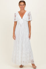 woman wearing a white lace maxi dress with a deep V-neck and short flutter sleeves