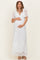 woman wearing a white lace maternity maxi dress and holding her baby bump