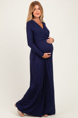 woman wearing a navy blue long sleeve maternity dress and holding her baby bump