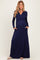 woman wearing a navy blue long sleeve maternity maxi dress with a wrap style and pockets, showing her baby bump