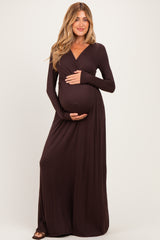 woman wearing a chocolate brown long sleeve maternity dress and holding her baby bump