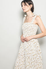 woman wearing a floral print square neck dress with tie straps and a flowy skirt
