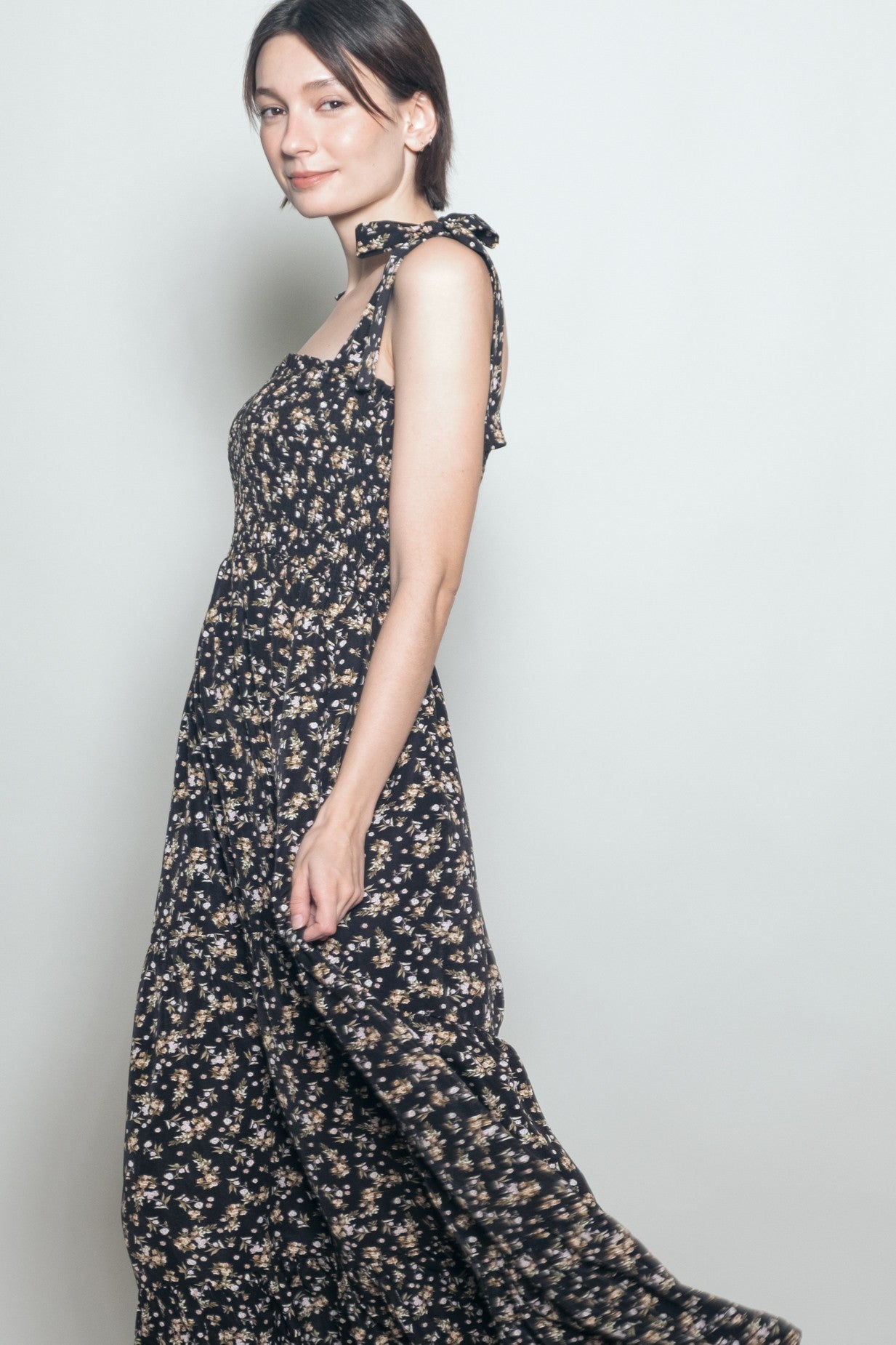 woman wearing a navy blue floral maxi dress with tie straps and a smocked bodice