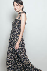 woman wearing a navy blue floral maxi dress with tie straps and a smocked bodice
