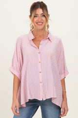 woman wearing a red and white striped maternity shirt with a button-down front and rolled sleeves, smiling at the camera