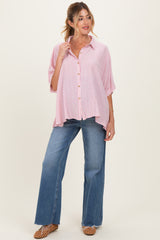woman wearing a red and white striped maternity blouse with buttons, paired with flared jeans and a relaxed fit