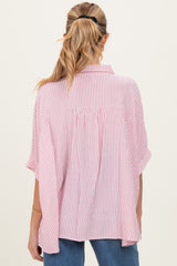 woman wearing a pink and white striped maternity top with a relaxed fit and short sleeves, showing the back view