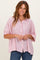 woman wearing a pink and white striped button-up shirt with a relaxed fit and short sleeves