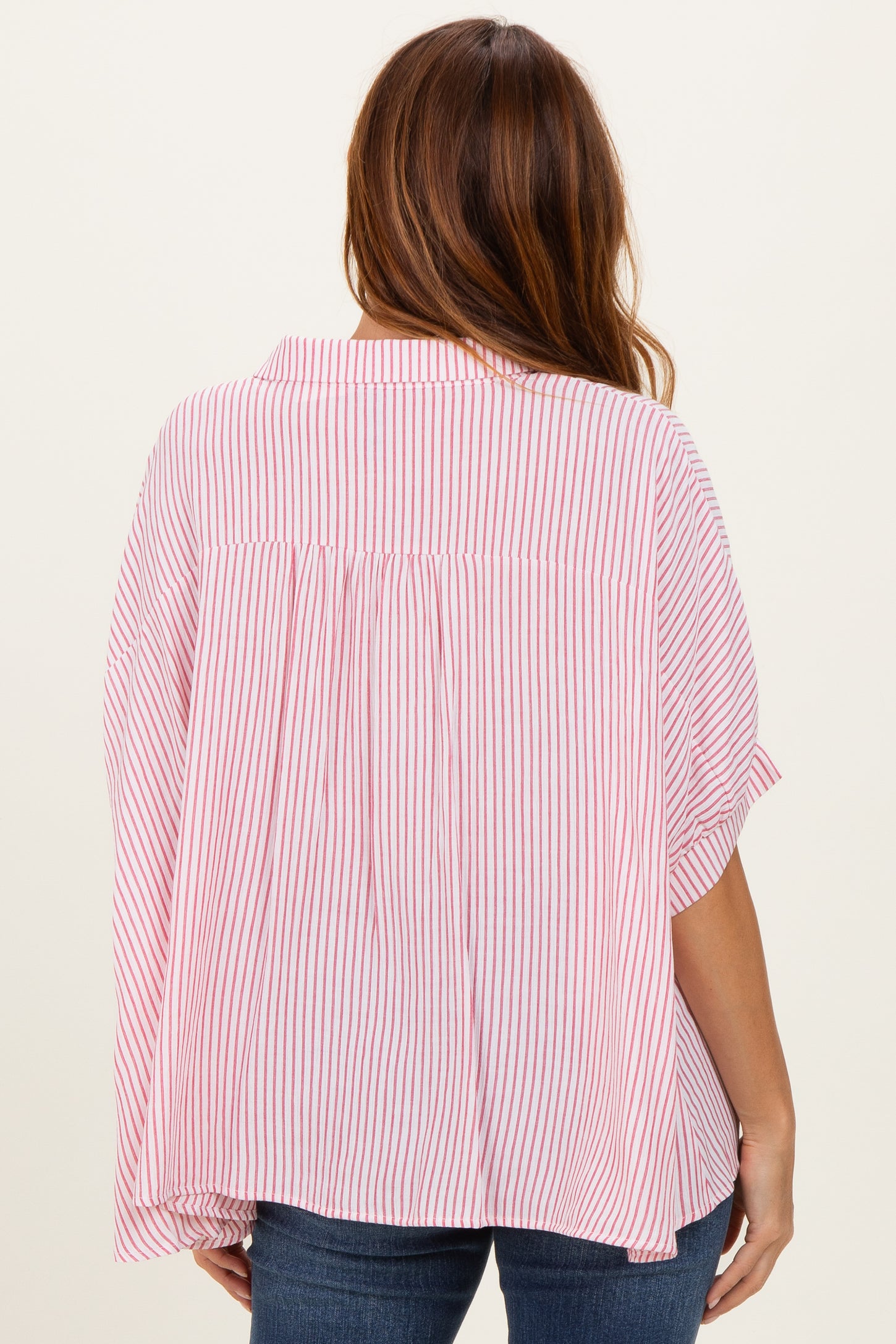 woman wearing a red and white striped oversized blouse with a pleated back and short sleeves