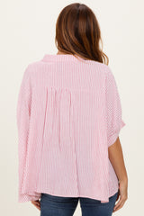 woman wearing a red and white striped oversized blouse with a pleated back and short sleeves